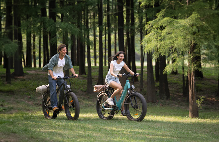 two people riding 2 engwe e26 fat tire electric bikes on grass