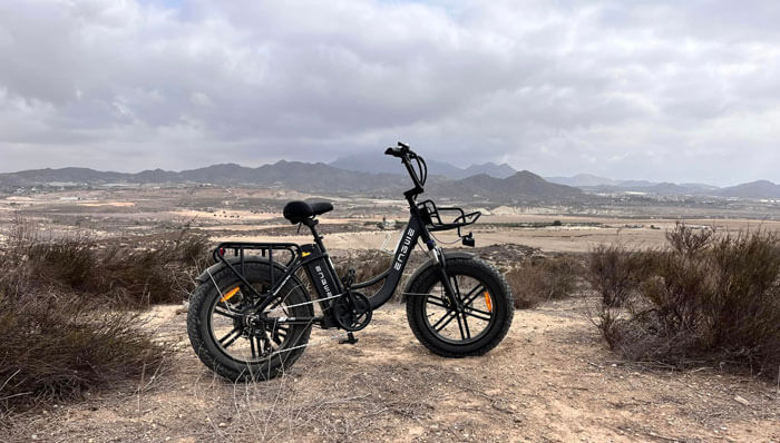 an engwe l20 electric bicycle with basket parked on the mountain