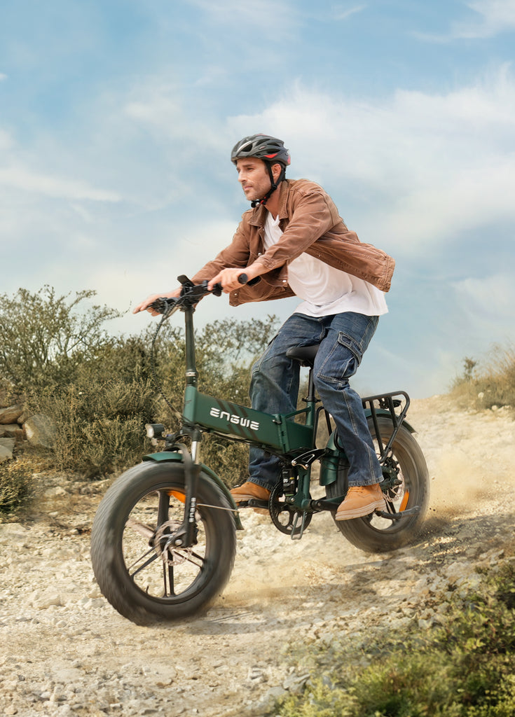 a man wearing an engwe helmet rides a green engwe engone pro 2.0 electric mountain bike on the gravel road